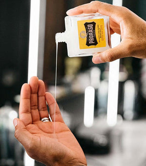 Proraso Wood & Spice Beard Balm being poured into palm of hand.