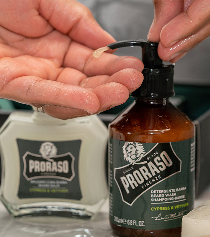 Proraso Cypress & Vetyver  Beard Wash being pumped into hand with Cypress & Vetyver Beard Balm in  the background.