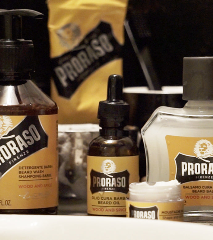 Proraso Wood & Spice Beard Wash, Proraso Wood & Spice Beard Oil, Proraso Wood & Spice Beard Balm and Proraso Wood & Spice Single Shaving Cream Tube on bathroom counter.