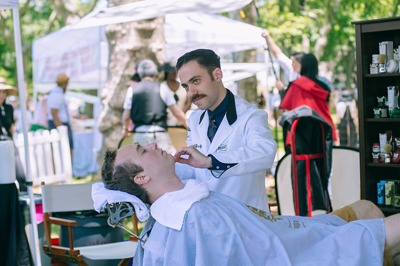 Proraso Master Barber Michael Haar shaving a client who is reclined in a barber chair