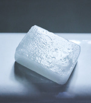 Post-Shave Stone sitting on side of bathtub wet